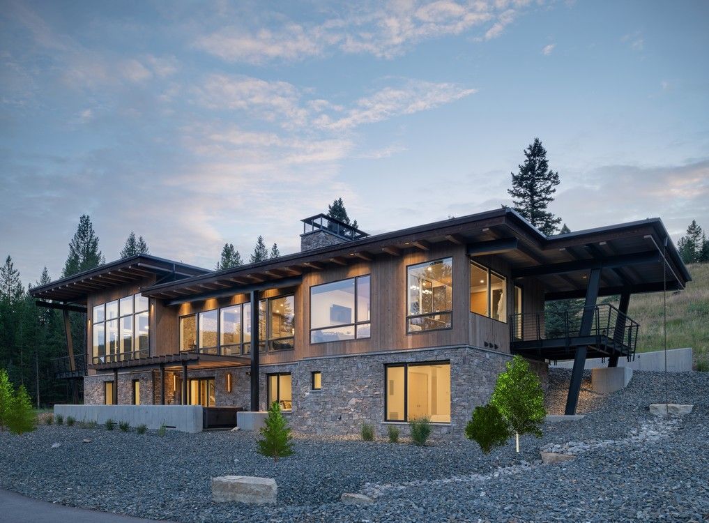 A large house with a lot of windows is sitting on top of a hill.