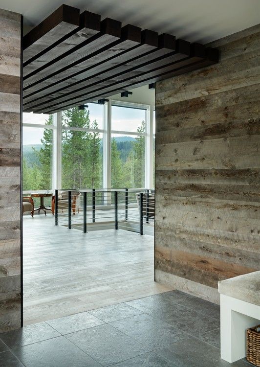 A room with a wooden wall and a large window