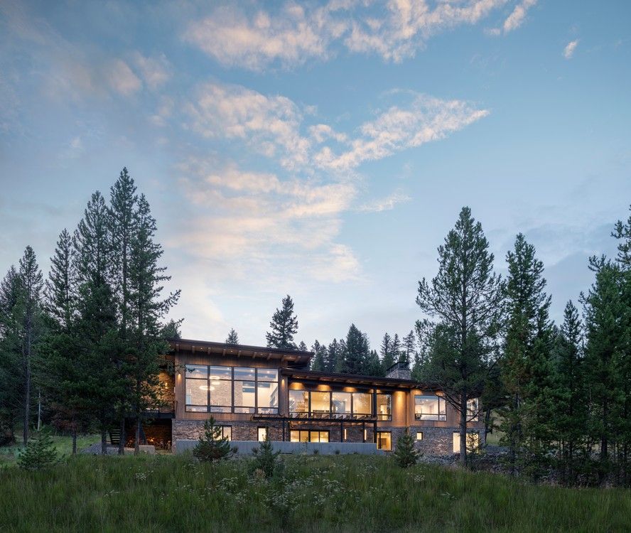 A large house with a lot of windows is surrounded by trees.