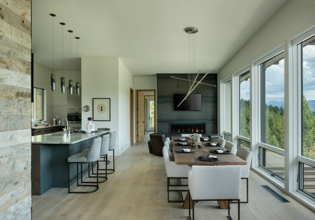 A dining room with a long table and chairs and a fireplace.