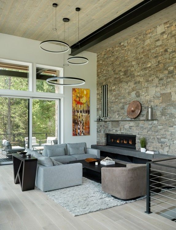 A living room with a stone wall and a fireplace