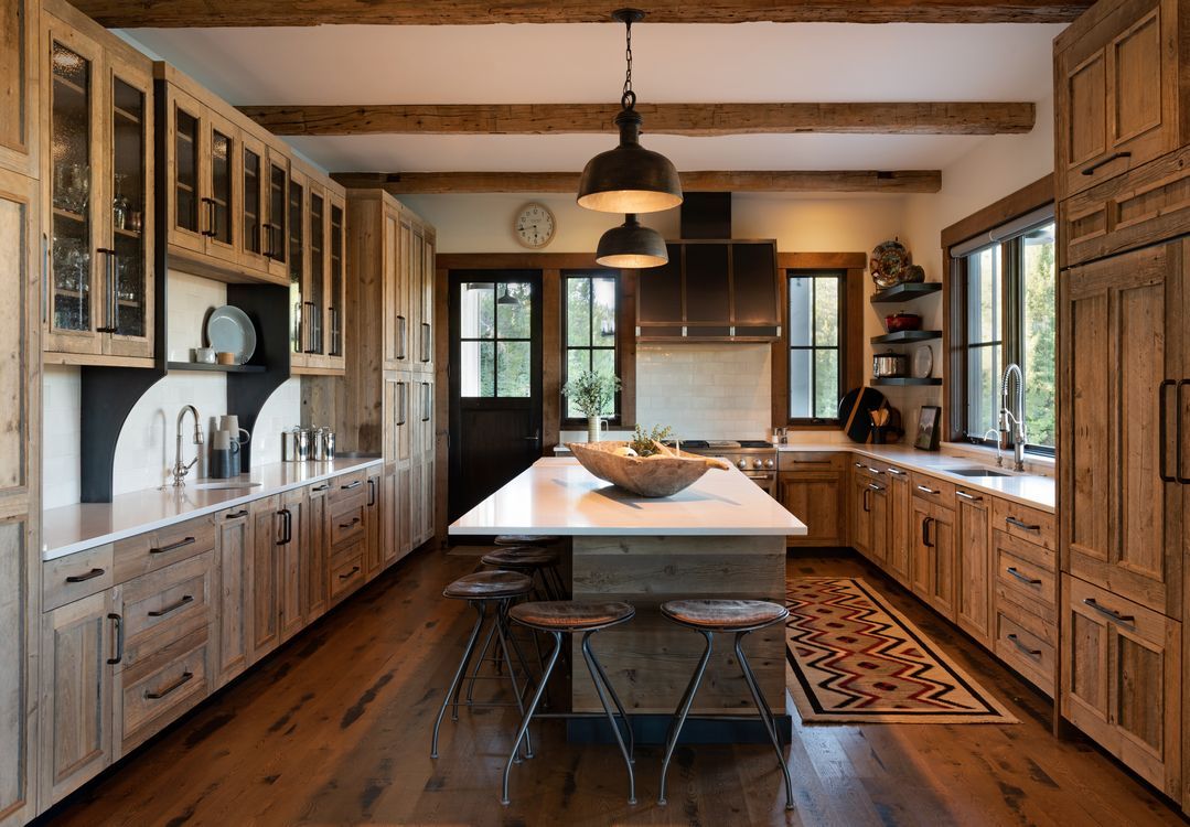 A kitchen with wooden cabinets and a large island in the middle.
