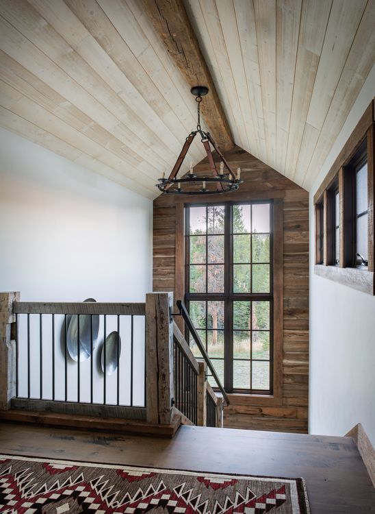 A wooden staircase with a chandelier hanging from the ceiling