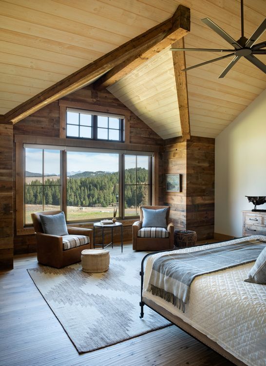 A bedroom with a bed , chairs and a ceiling fan