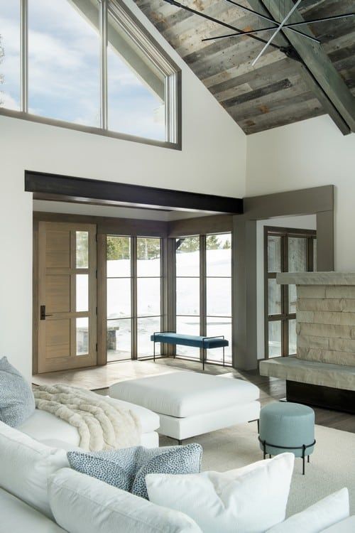 A living room with a vaulted ceiling and lots of windows