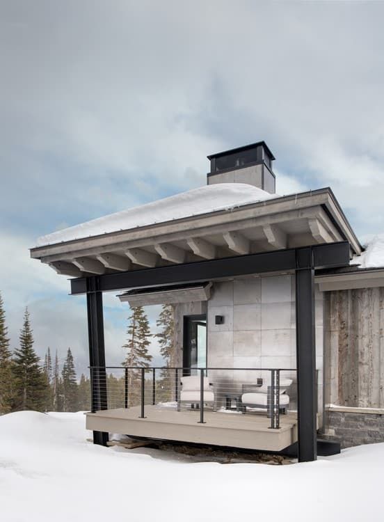 A house with a porch and a roof that is covered in snow.