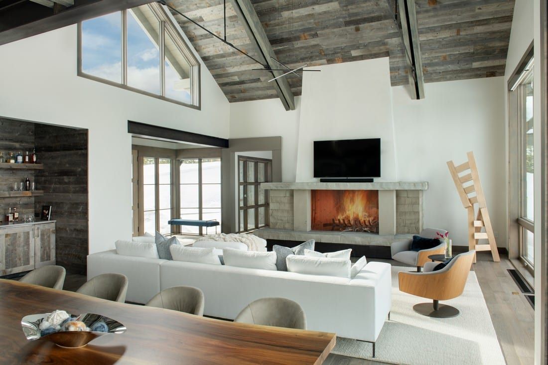A living room with a fireplace , couch , chairs , table and television.