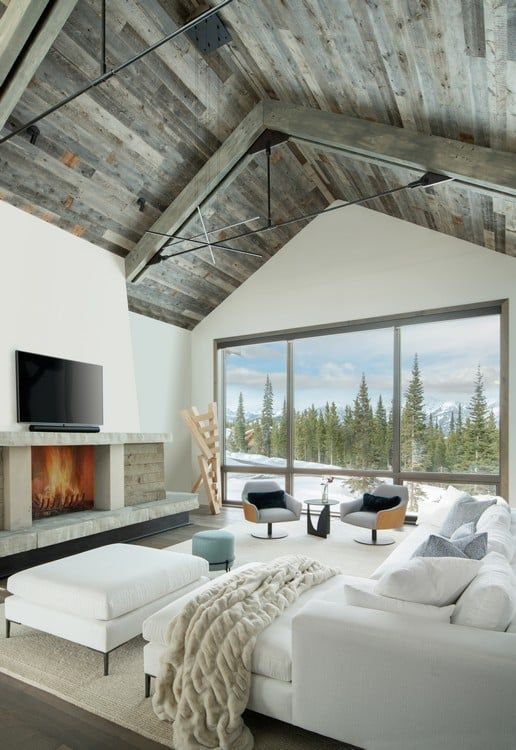 A living room with a vaulted ceiling and a fireplace