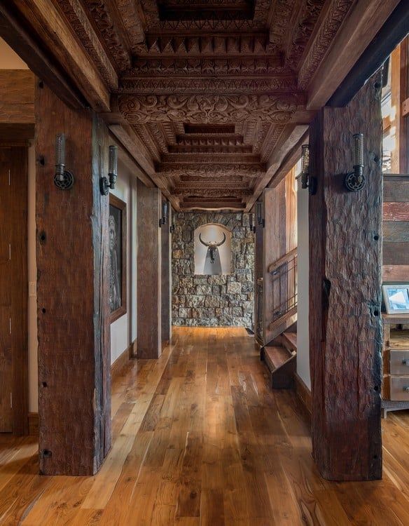 A hallway with wooden pillars and a picture of a bull on the wall