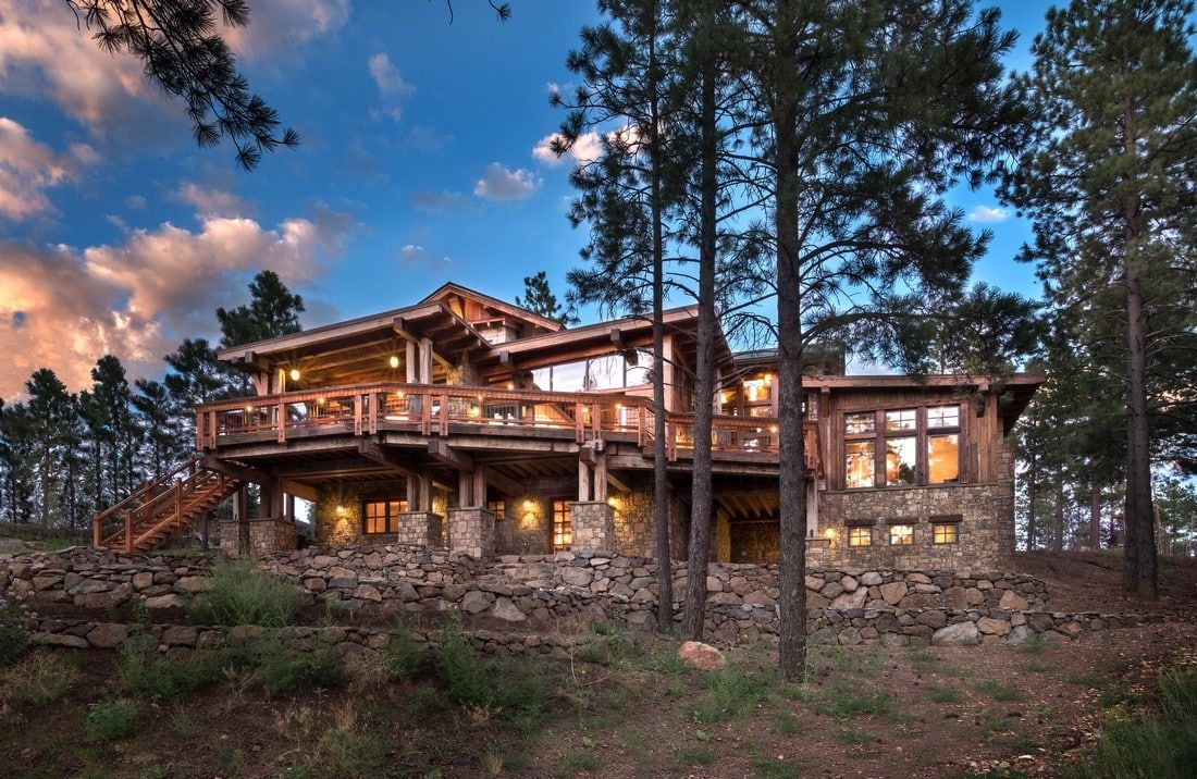 A large house with a lot of windows is surrounded by trees.