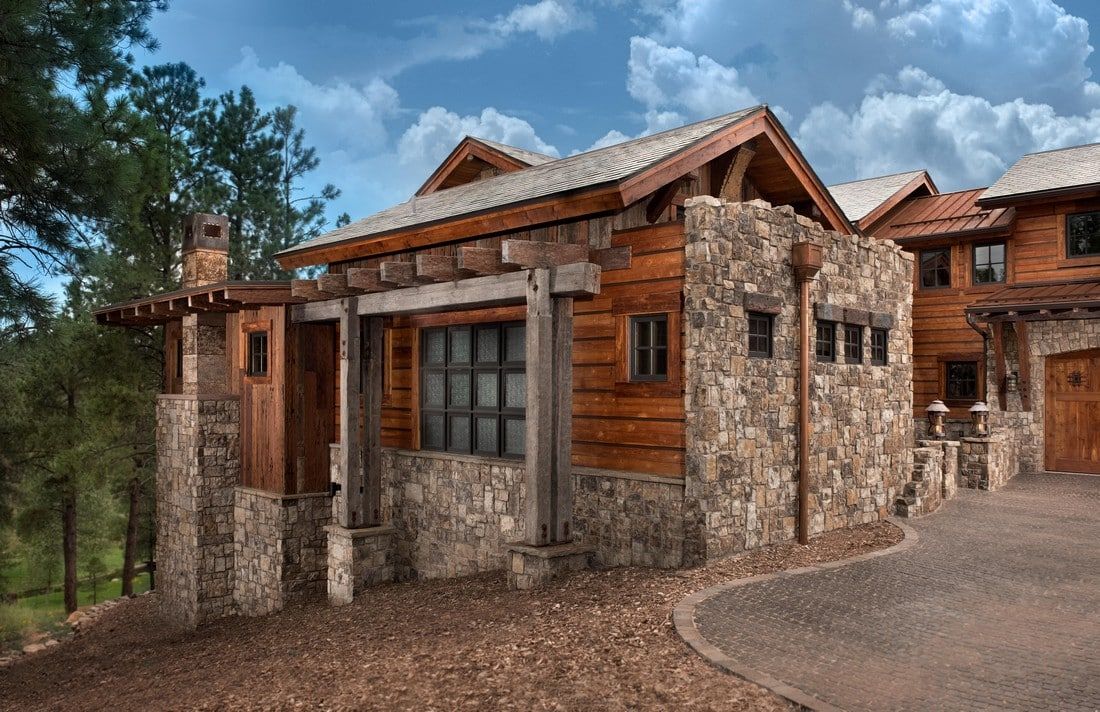 A large wooden and stone house with a driveway leading to it