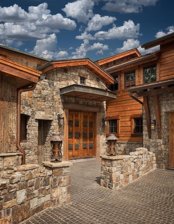 A wooden house with a stone wall surrounding it