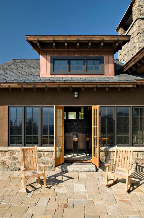 A house with rocking chairs in front of it