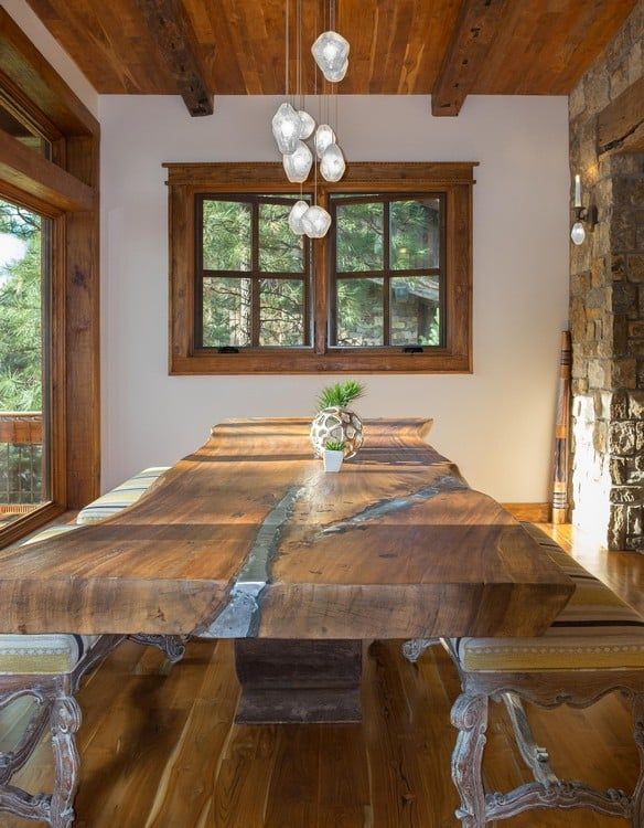 A dining room with a long wooden table and a window