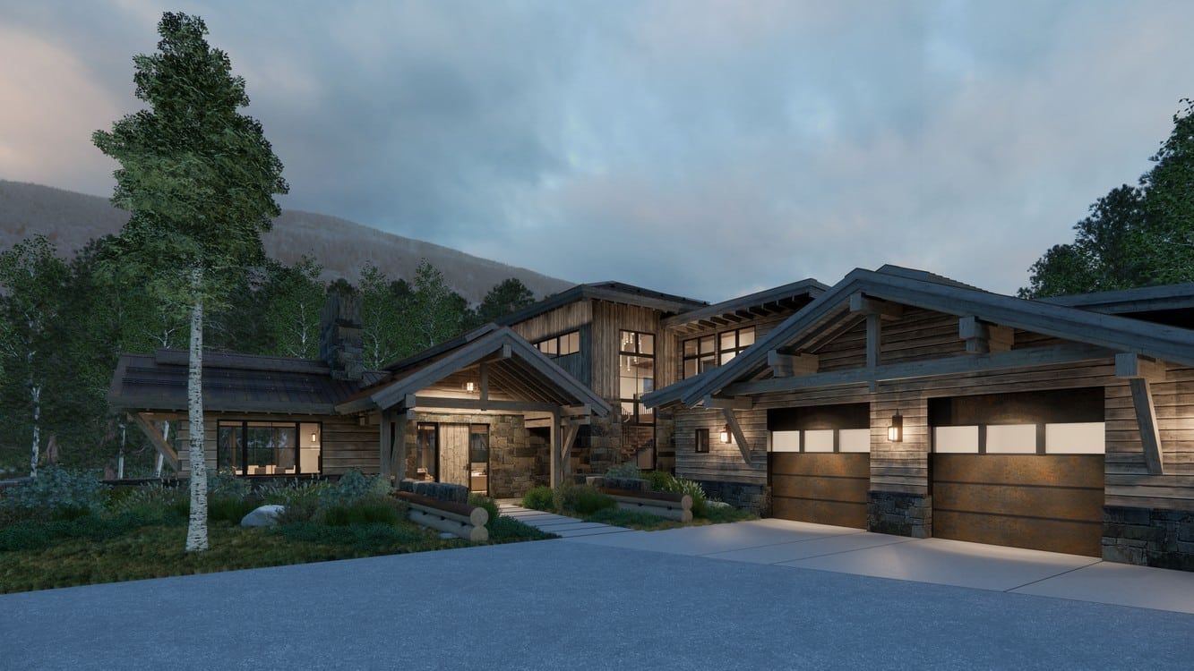 A large house with a lot of windows is surrounded by trees and mountains.