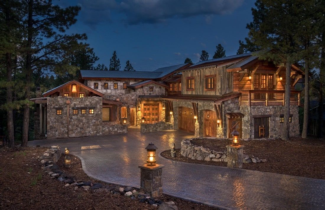 A large stone house is surrounded by trees at night.