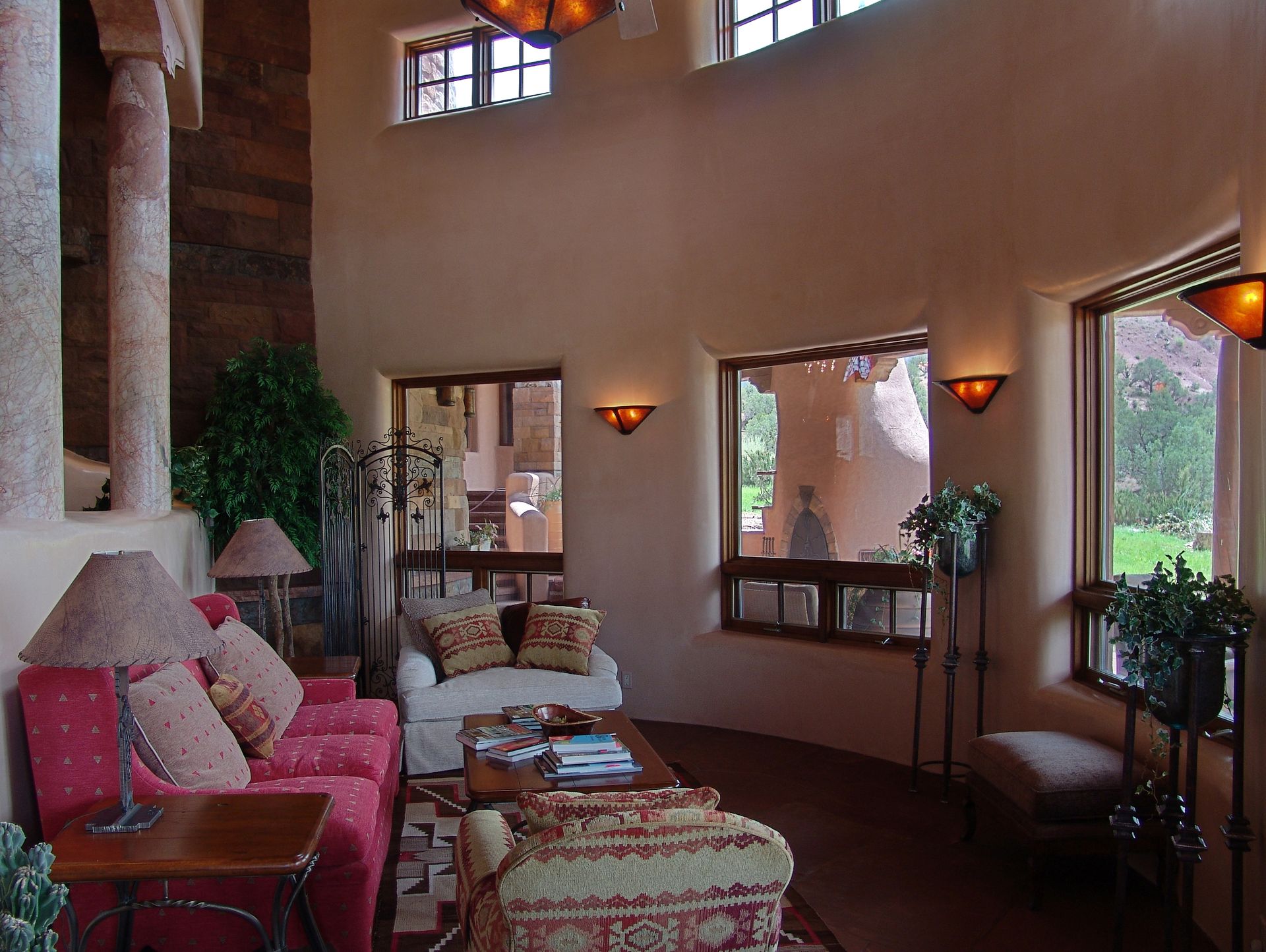 A living room with a red couch and a white chair