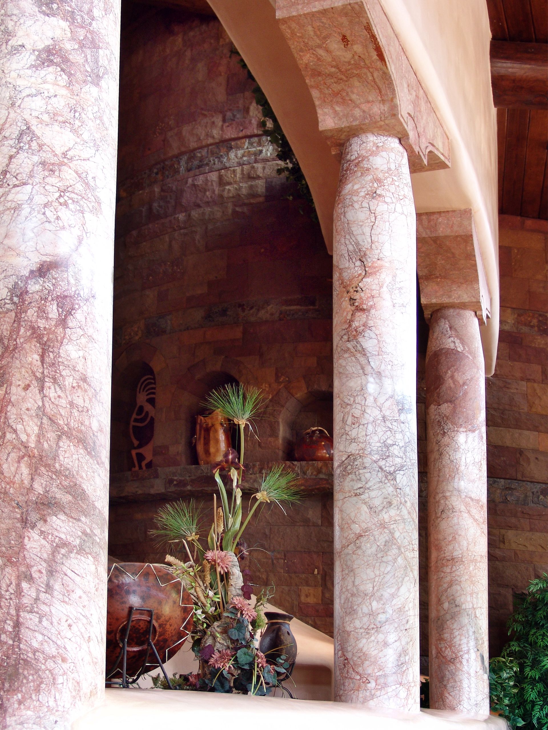 A row of columns with a vase of flowers in the middle