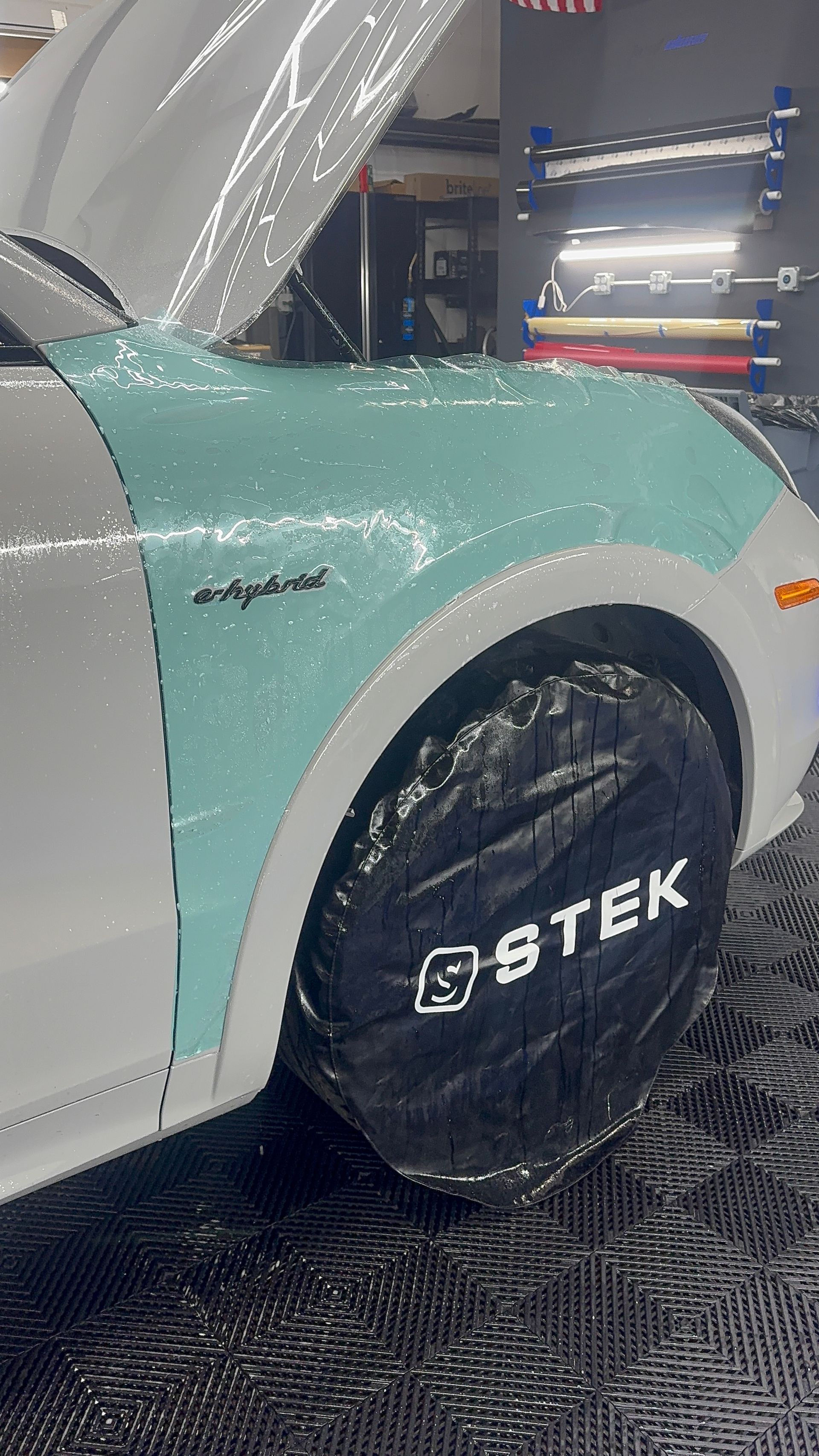 Car with blue wrap on front panel, protected tire with 