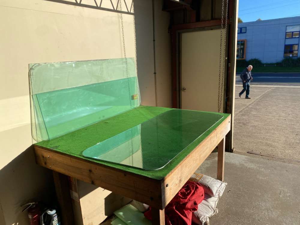 A Green Table With A Lot Of Glass On It — Eurobodalla Windscreens in Moruya, NSW