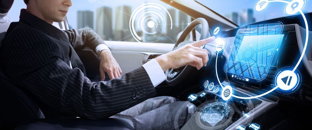A Man In A Suit Is Driving A Self Driving Car — Eurobodalla Windscreens in Narooma, NSW