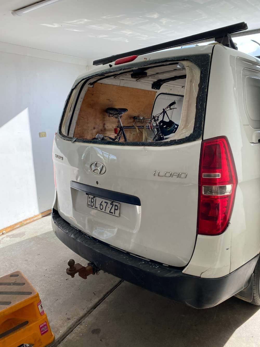 A White Van With A Broken Windshield Is Parked In A Garage — Eurobodalla Windscreens in Moruya, NSW