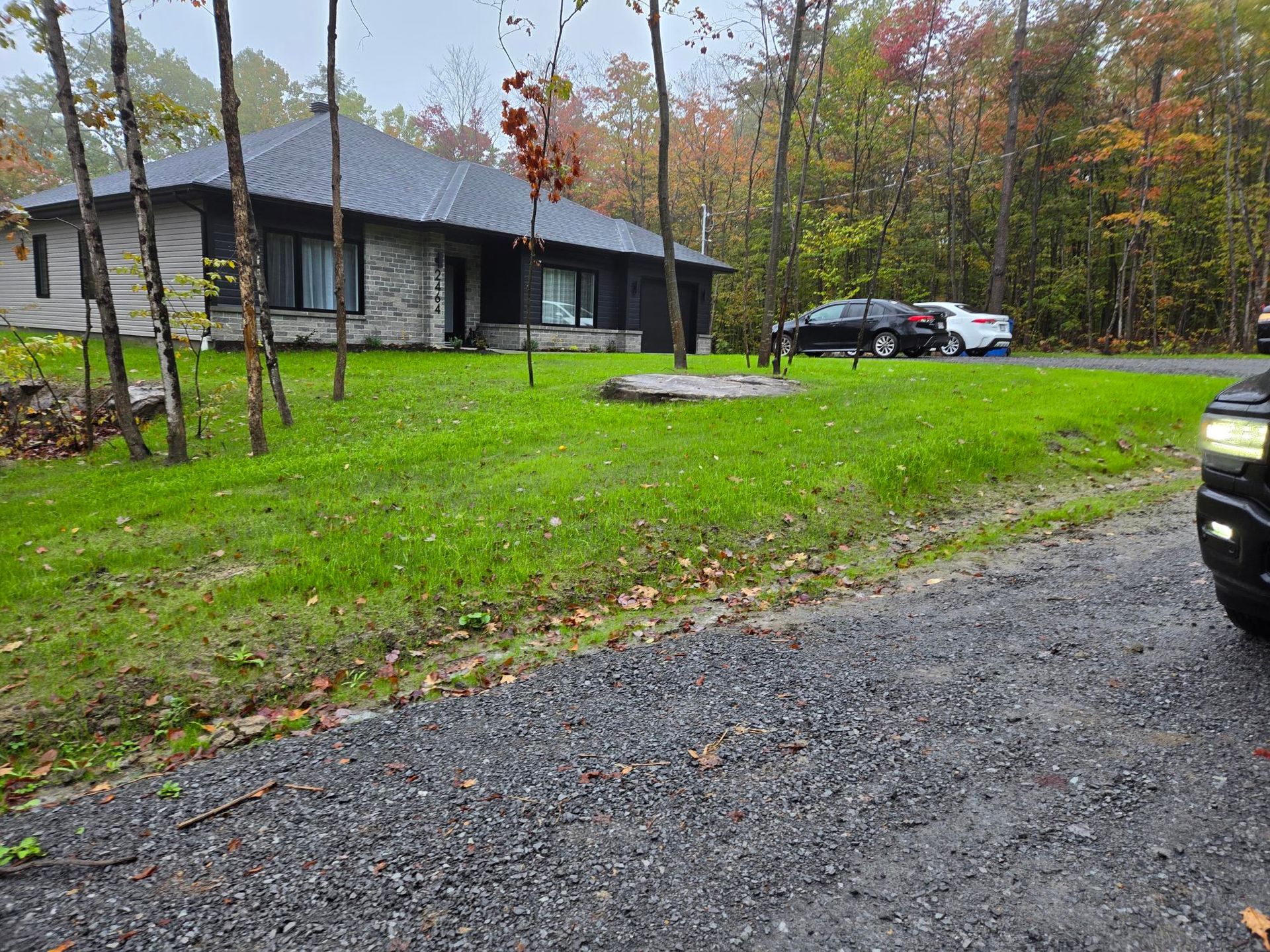 Un camion est garé devant une maison dans les bois.