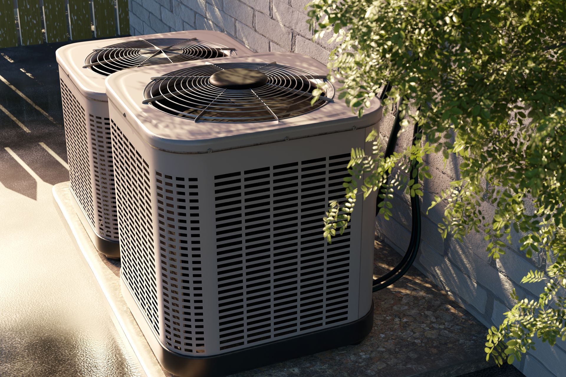 Two outdoor air conditioning units beside a wall, with tree branches casting shadows nearby.