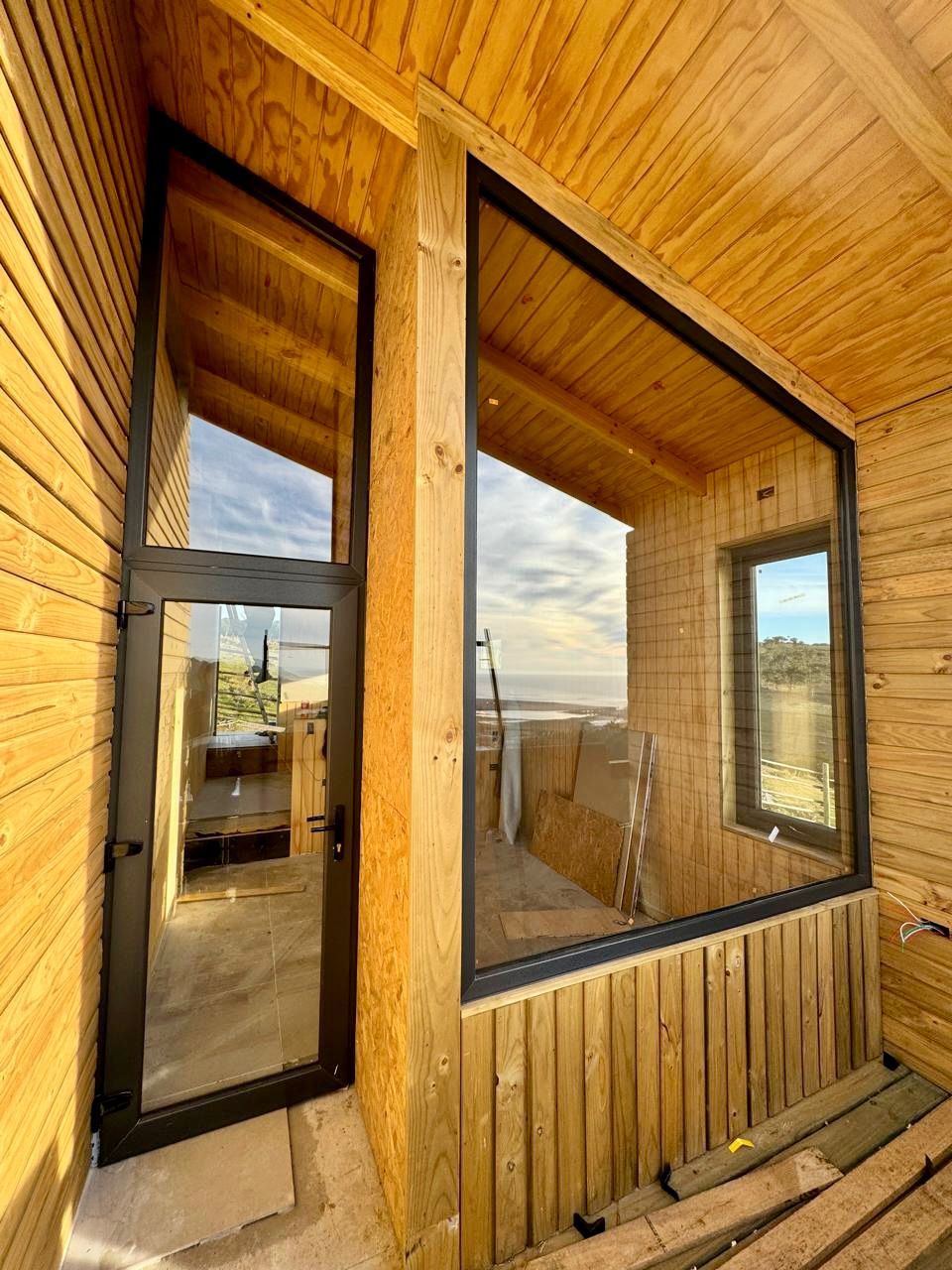 Un edificio de madera con una gran ventana y una puerta.
