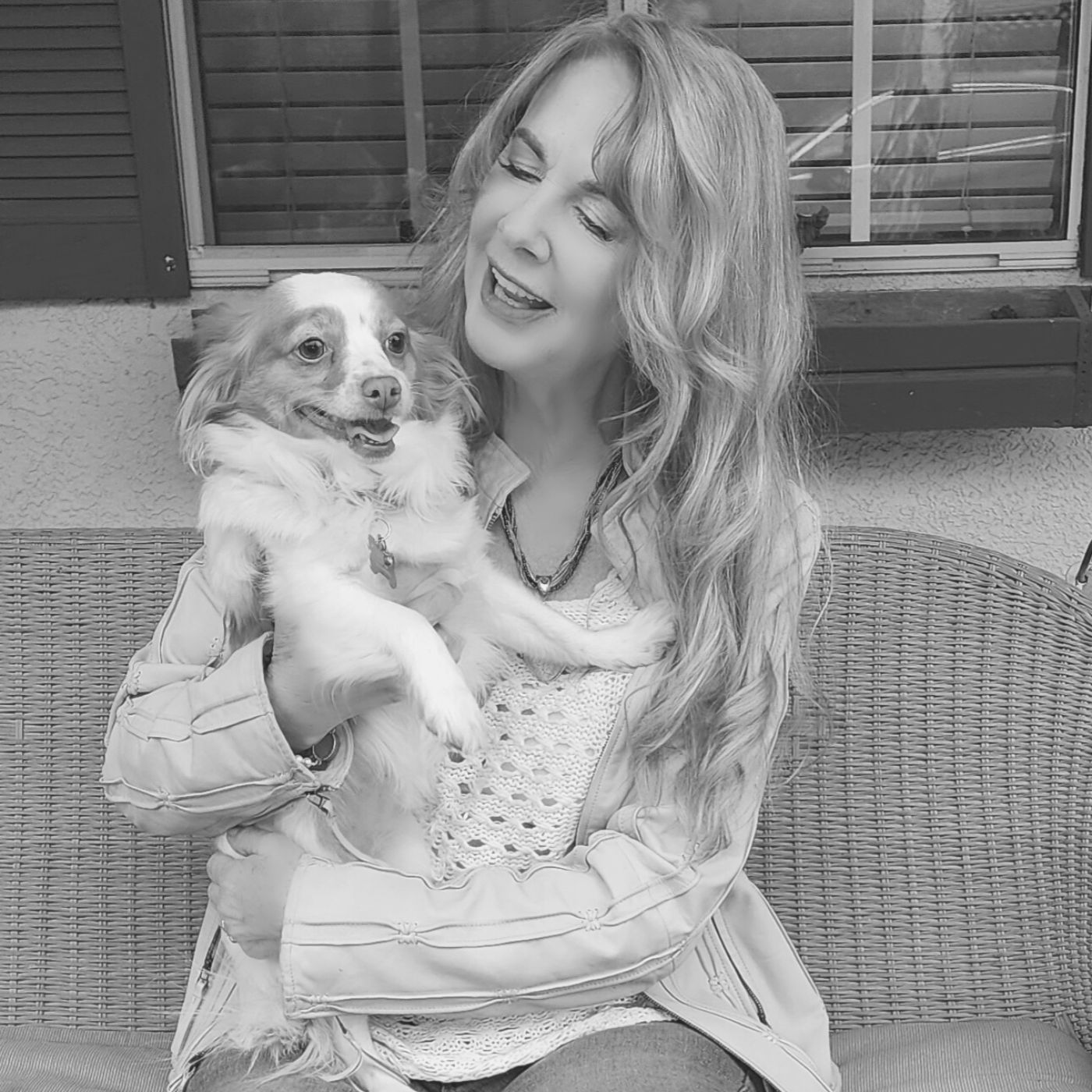 A woman is holding a small dog in her arms.