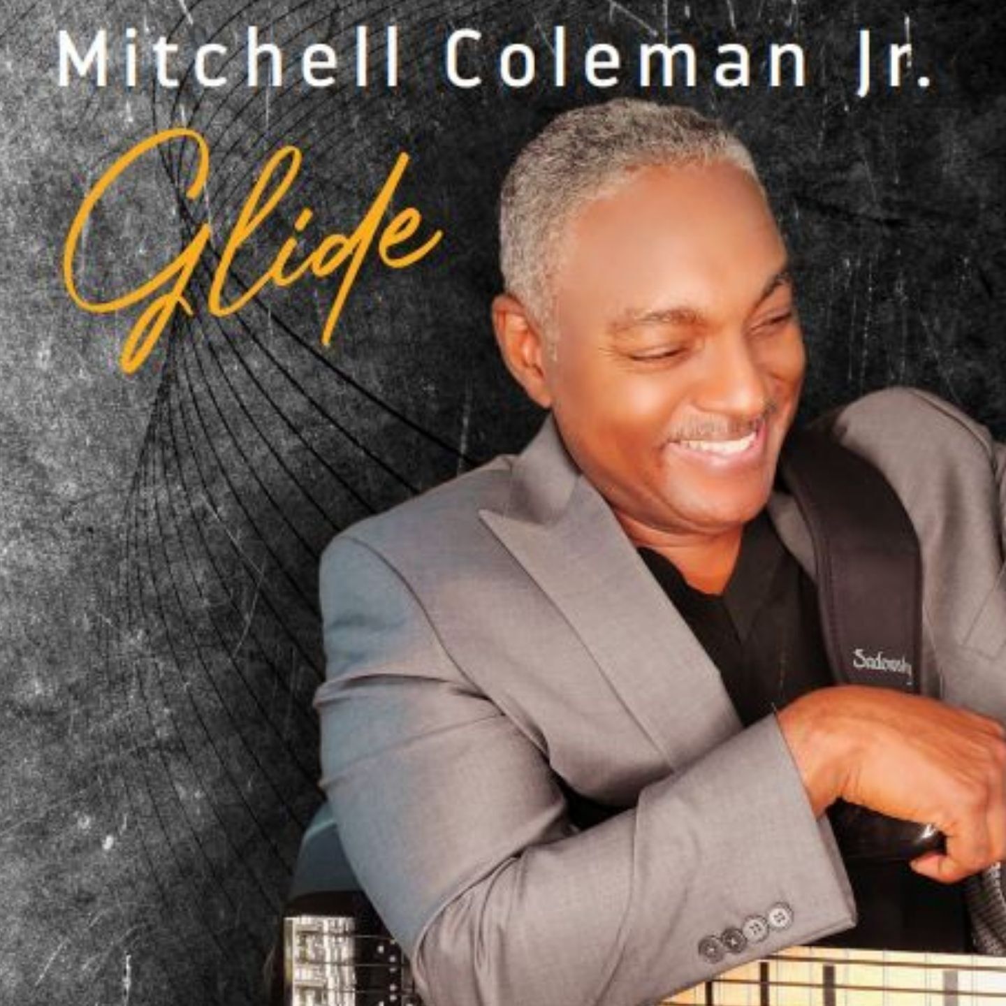 Album cover featuring Mitchell Coleman Jr. smiling in a gray suit with the title “Glide” on a dark textured background