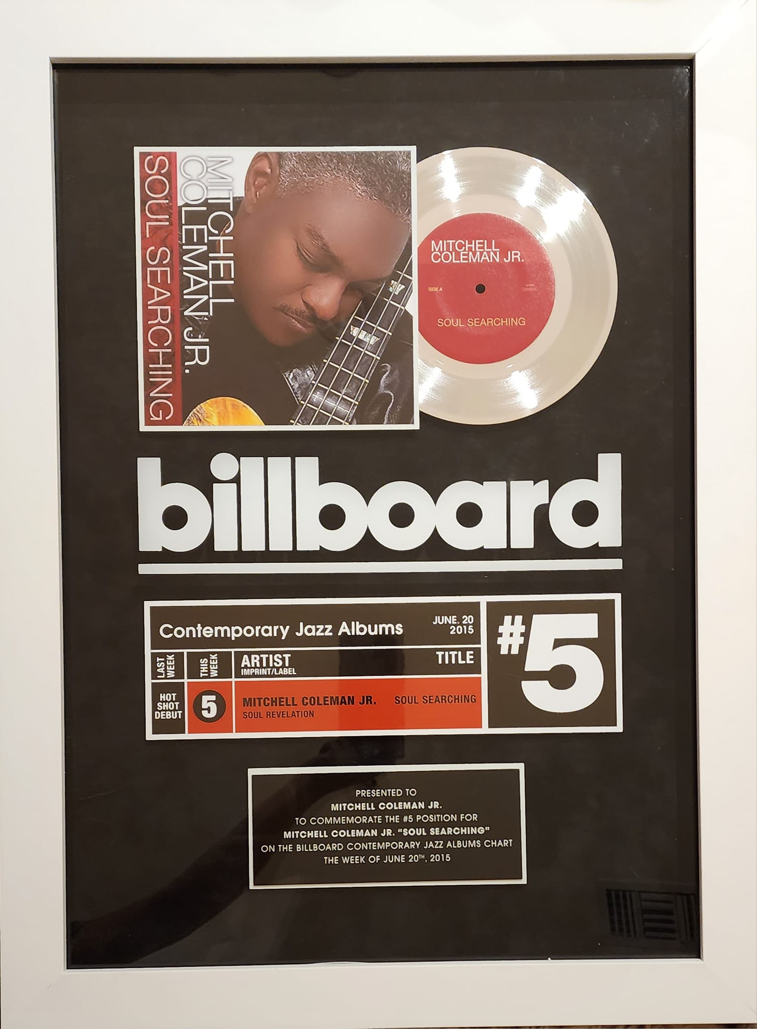 A framed billboard with a picture of a man and a record