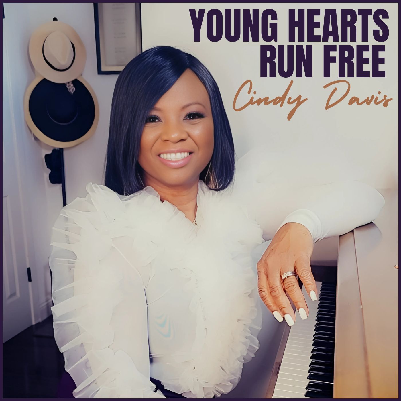 Woman smiling beside piano under text “Young Hearts Run Free” and “Cindy Davis”