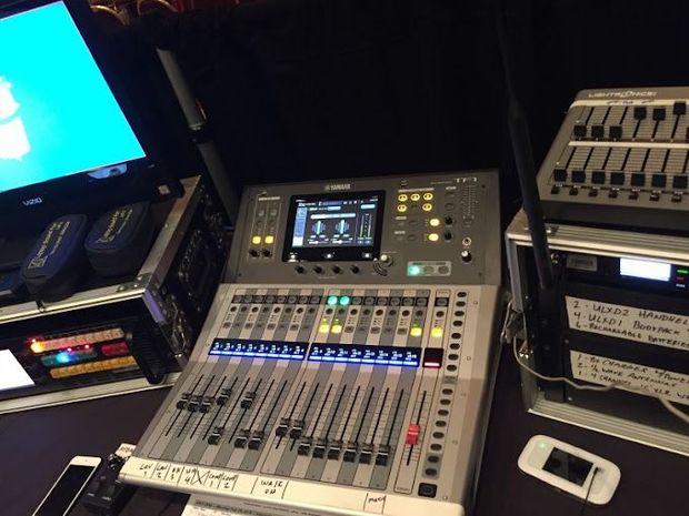 A yamaha mixer sits on a table next to a monitor