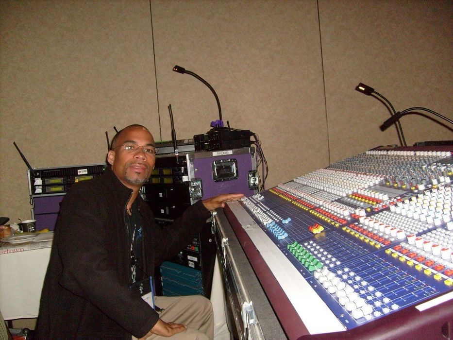 A man is sitting in front of a large mixer