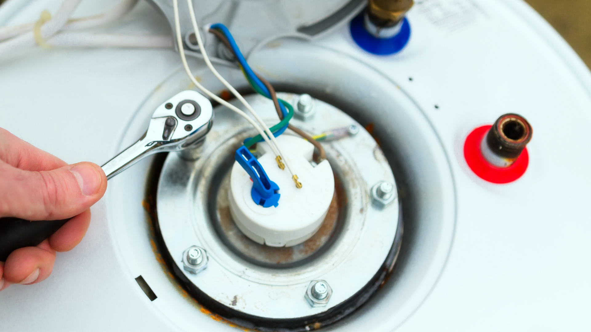 a person is fixing a water heater with a wrench