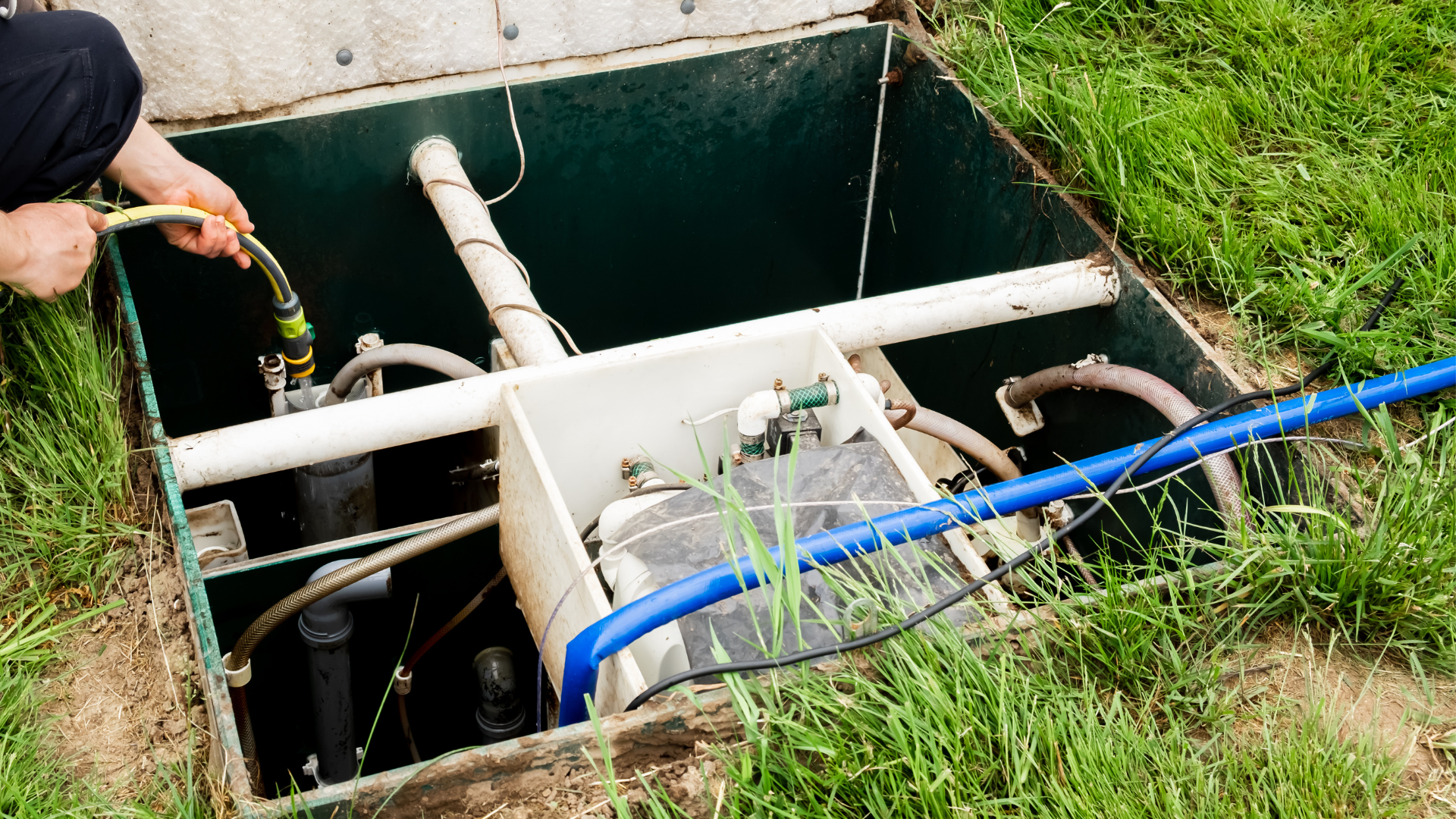 a person is working on a septic tank with a hose