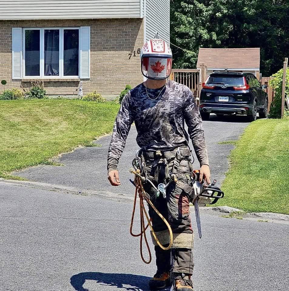 A man wearing a canadian hat is walking down a street
