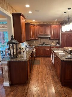 A kitchen with wooden cabinets and granite counter tops.