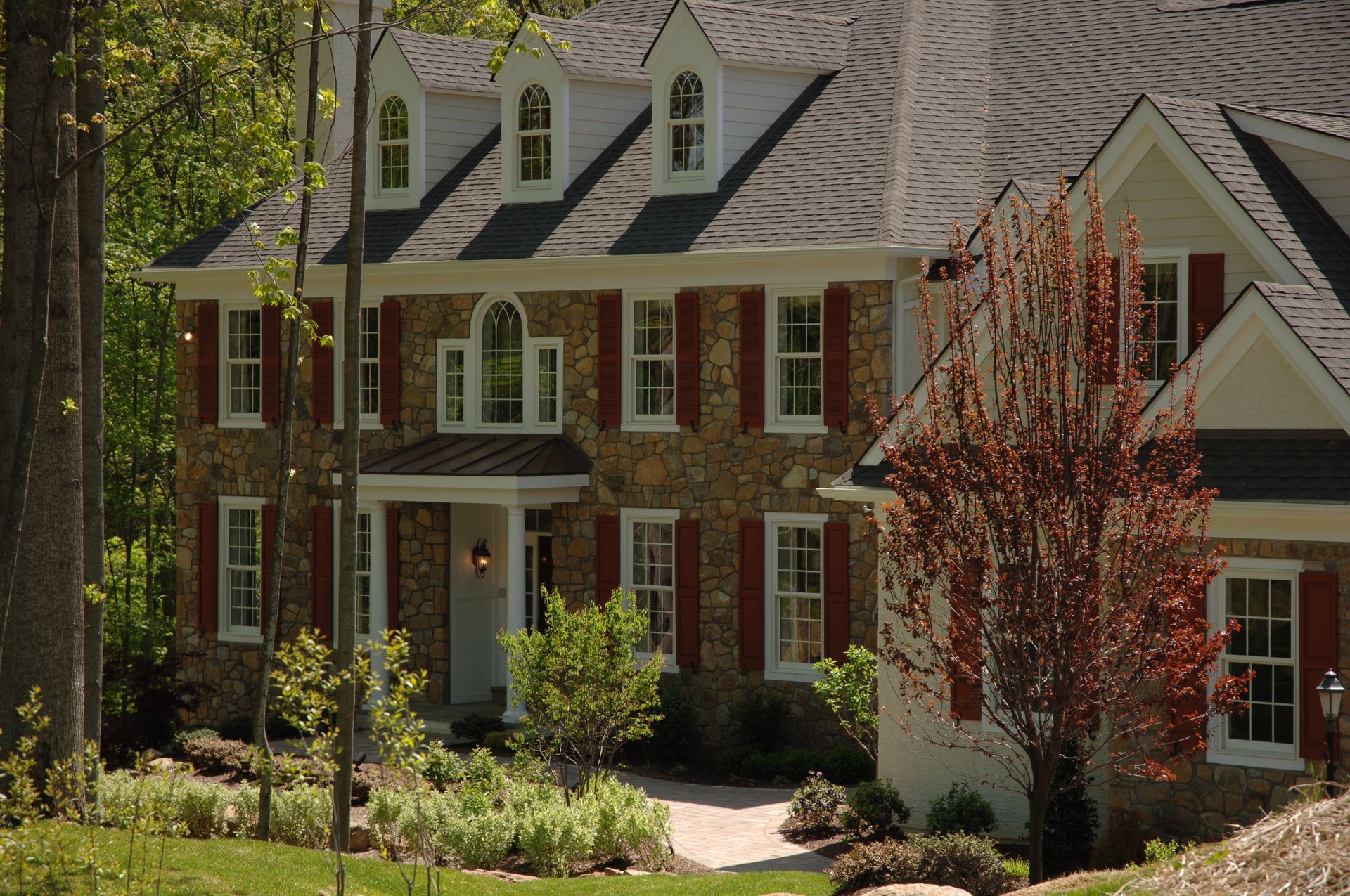 A large brick house with white trim and red shutters