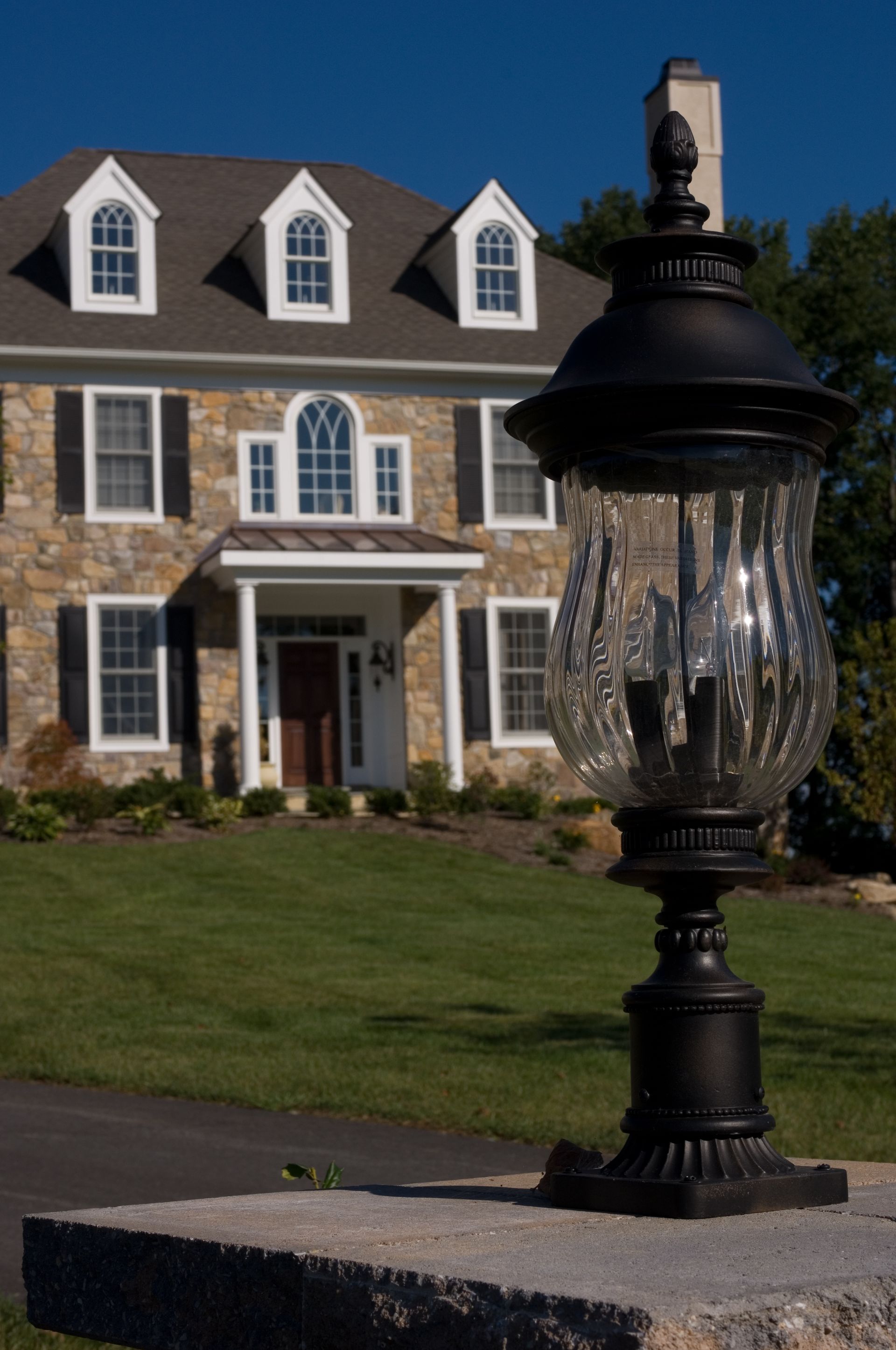 A lamp post in front of a large house