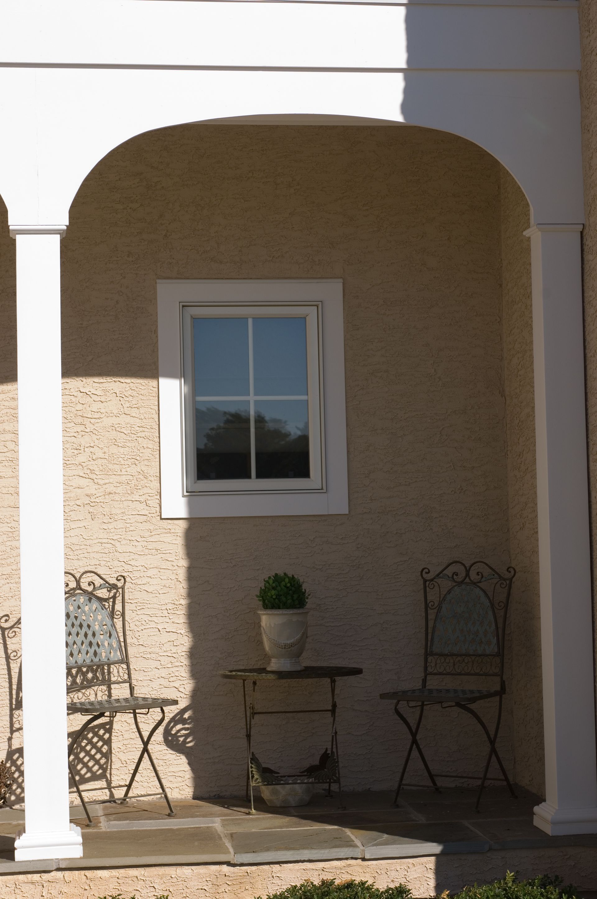 A porch with a table and chairs and a window