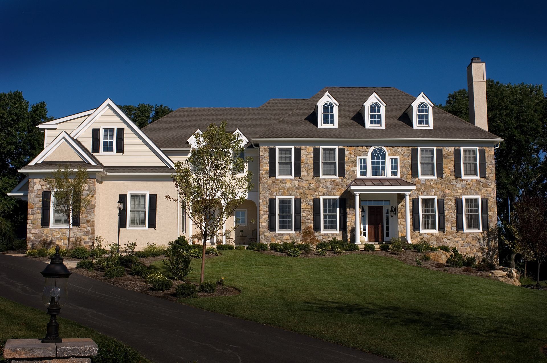 A large house with a lot of windows and a driveway