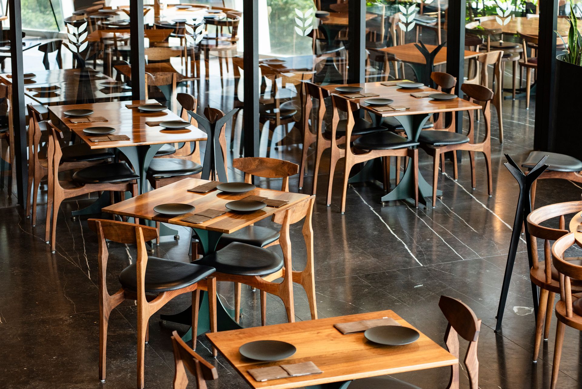 Cafetería moderna de madera con grandes ventanales.