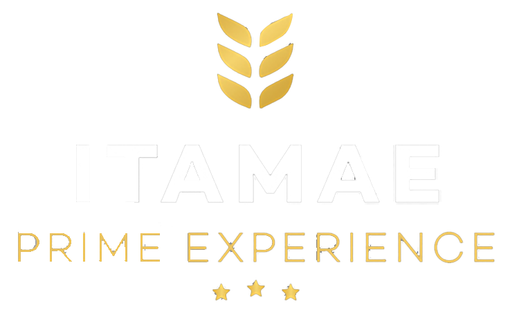 Logotipo blanco de “TAMAE PRIME EXPERIENCE” con emblema de trigo dorado y estrellas