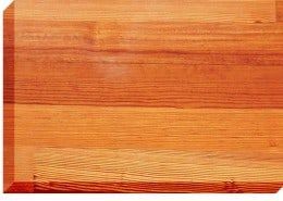 Close-up of a rectangular wood block with visible grain in shades of orange and brown.