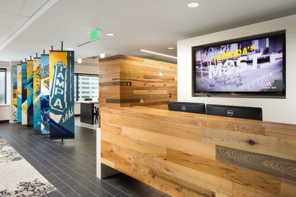 Reception area with wood paneling, TV, and colorful banners.