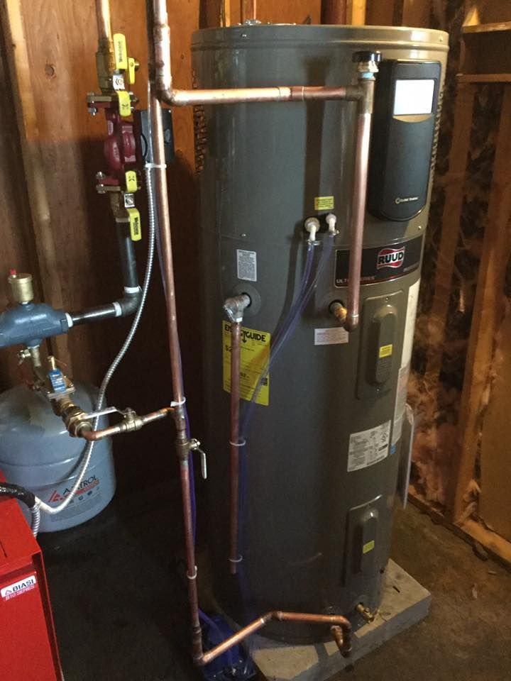 Water heater and nearby plumbing in a utility closet, with copper pipes and a blue expansion tank.