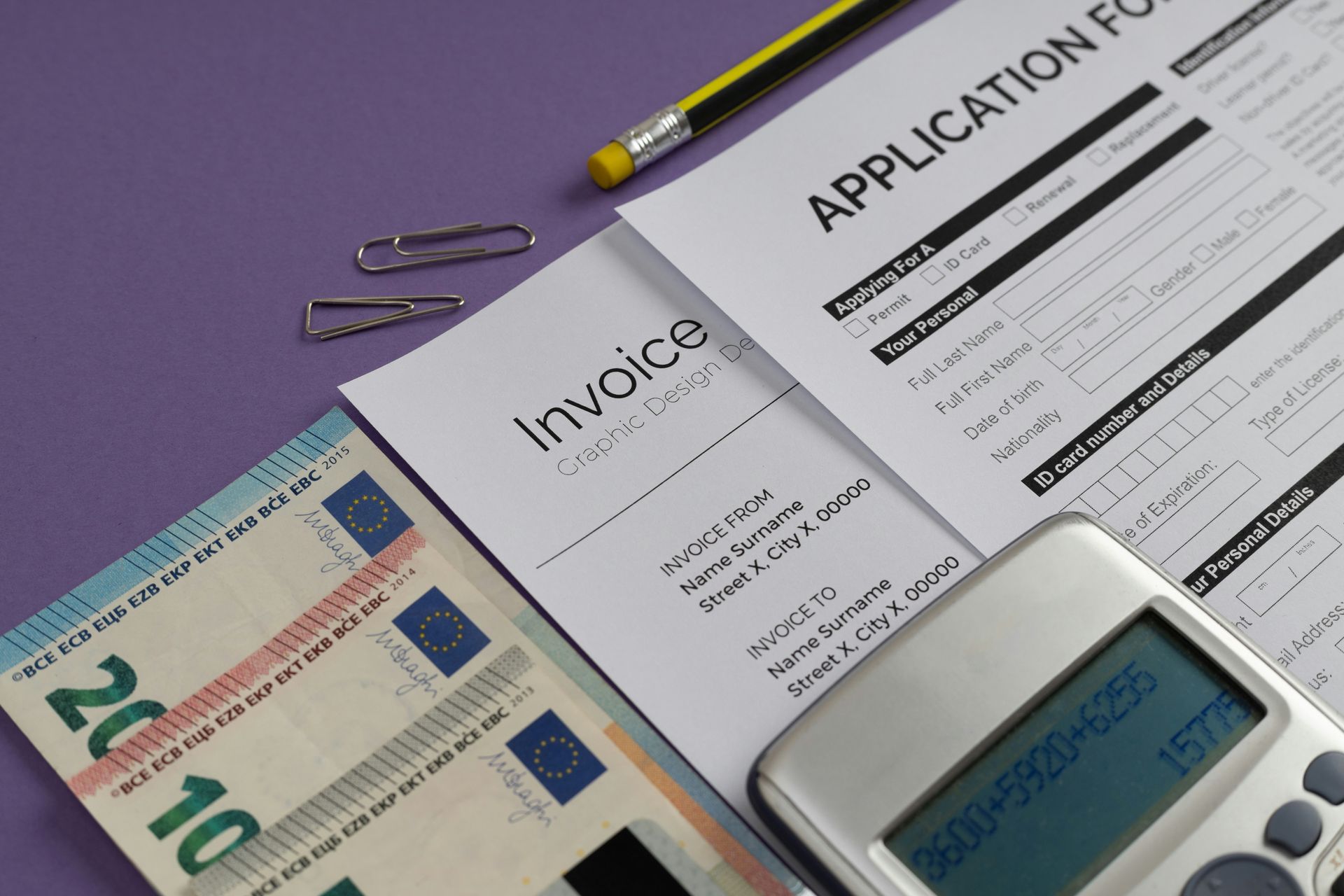 Forms, cash, calculator, and pen on a purple surface.