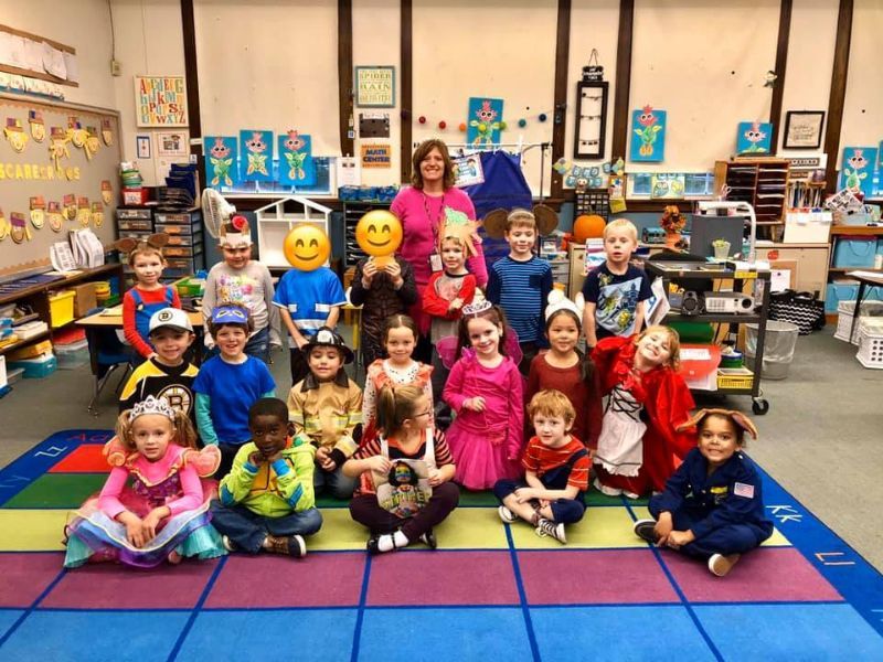 A group of children are posing for a picture in a classroom
